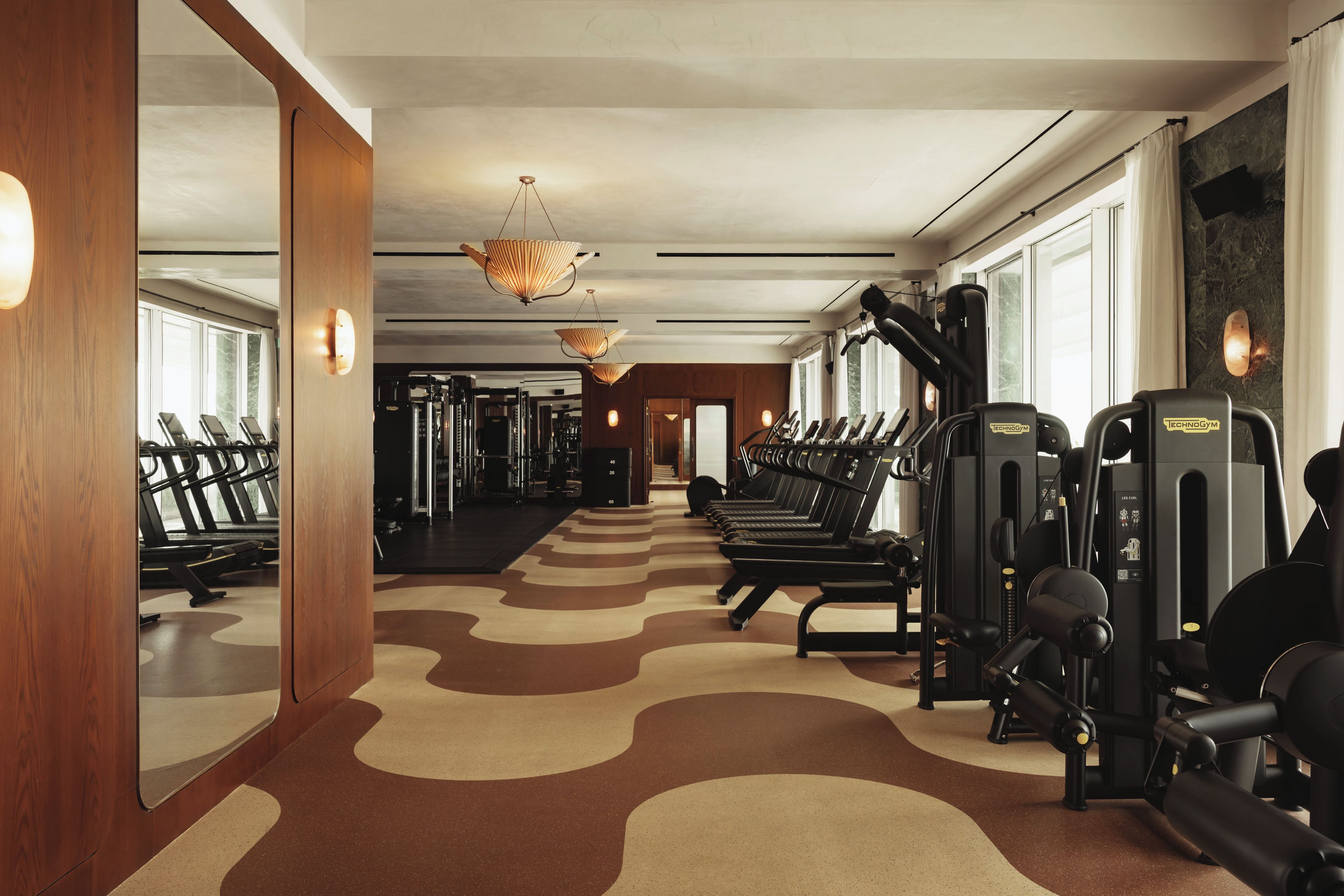 A gym with treadmills, weight machines, and a patterned floor.