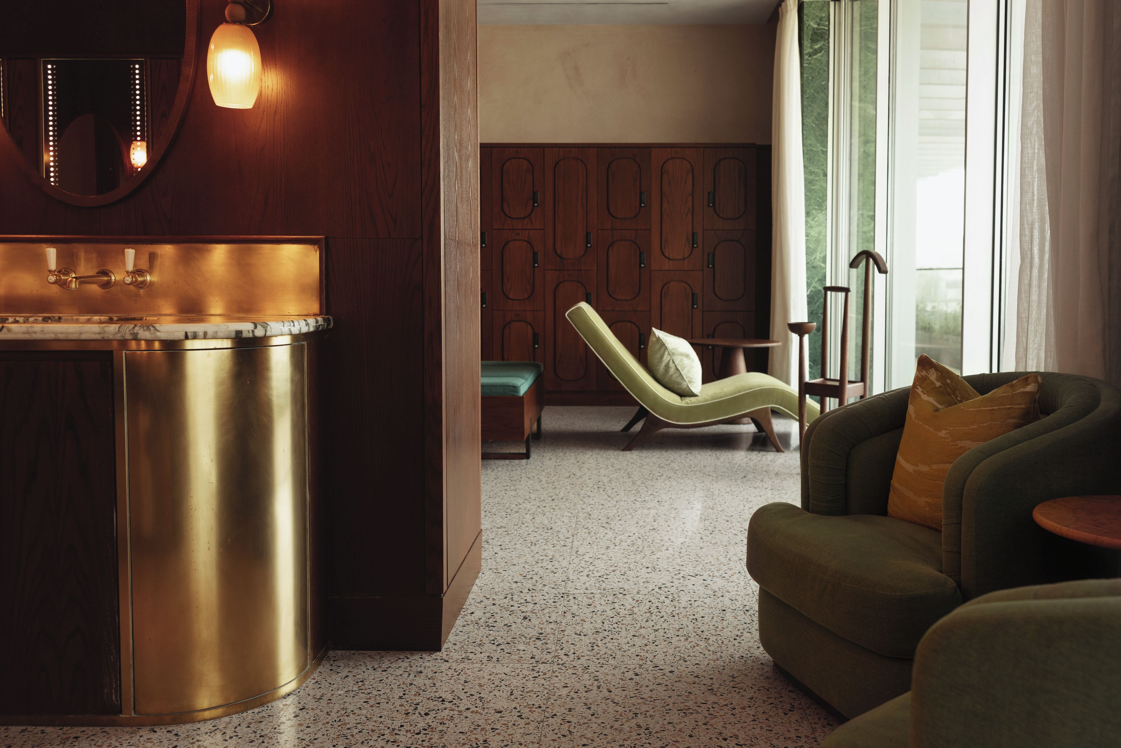 Ein modernes Interieur mit Küchenzeile, Sitzgelegenheit und Blick durch ein Fenster.