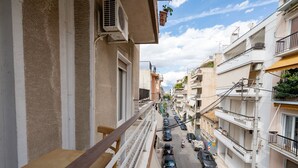 Une rue étroite, bordée de voitures garées et d’immeubles des deux côtés.