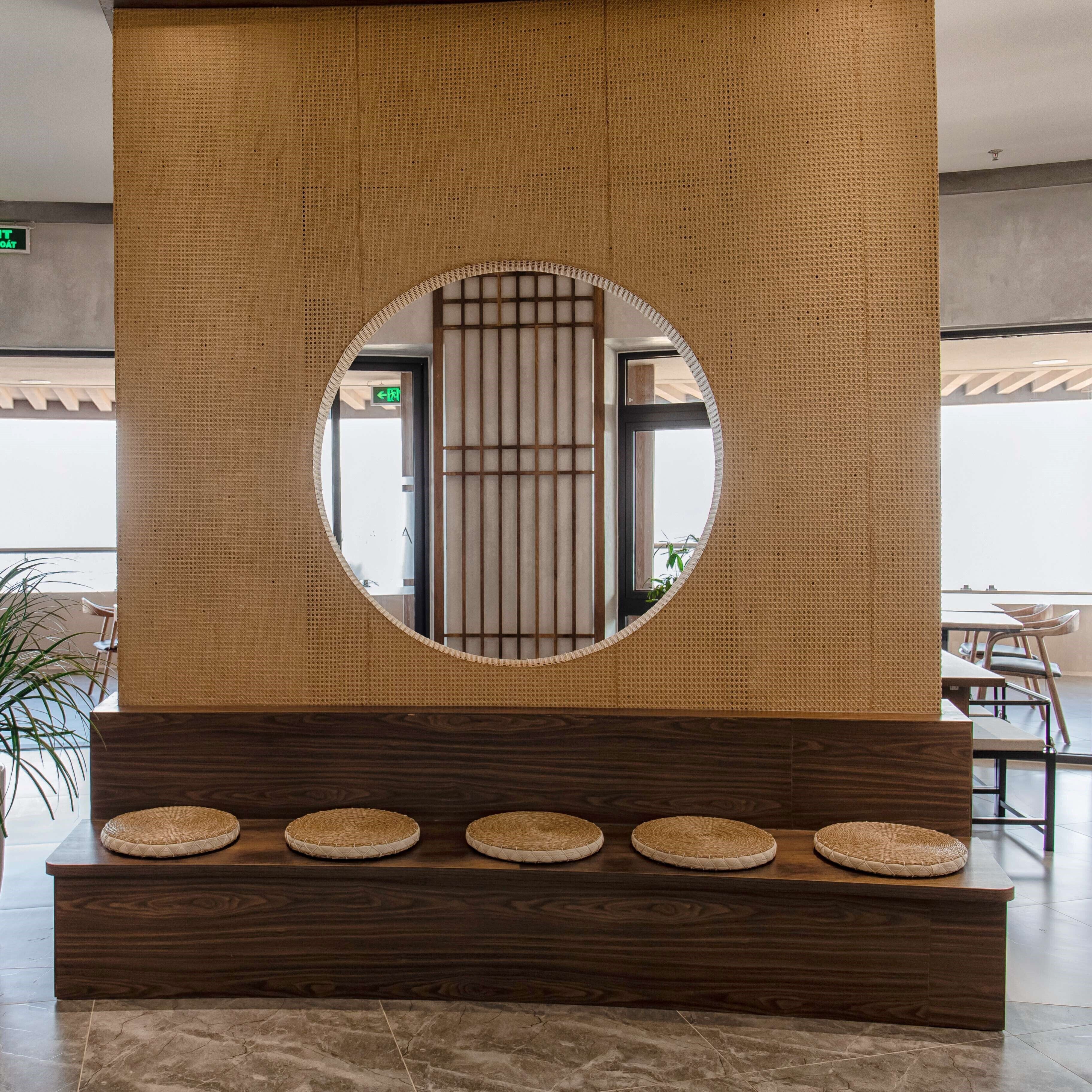 A reception area with a wooden reception desk, a circular mirror, and a traditional Japanese-style partition.