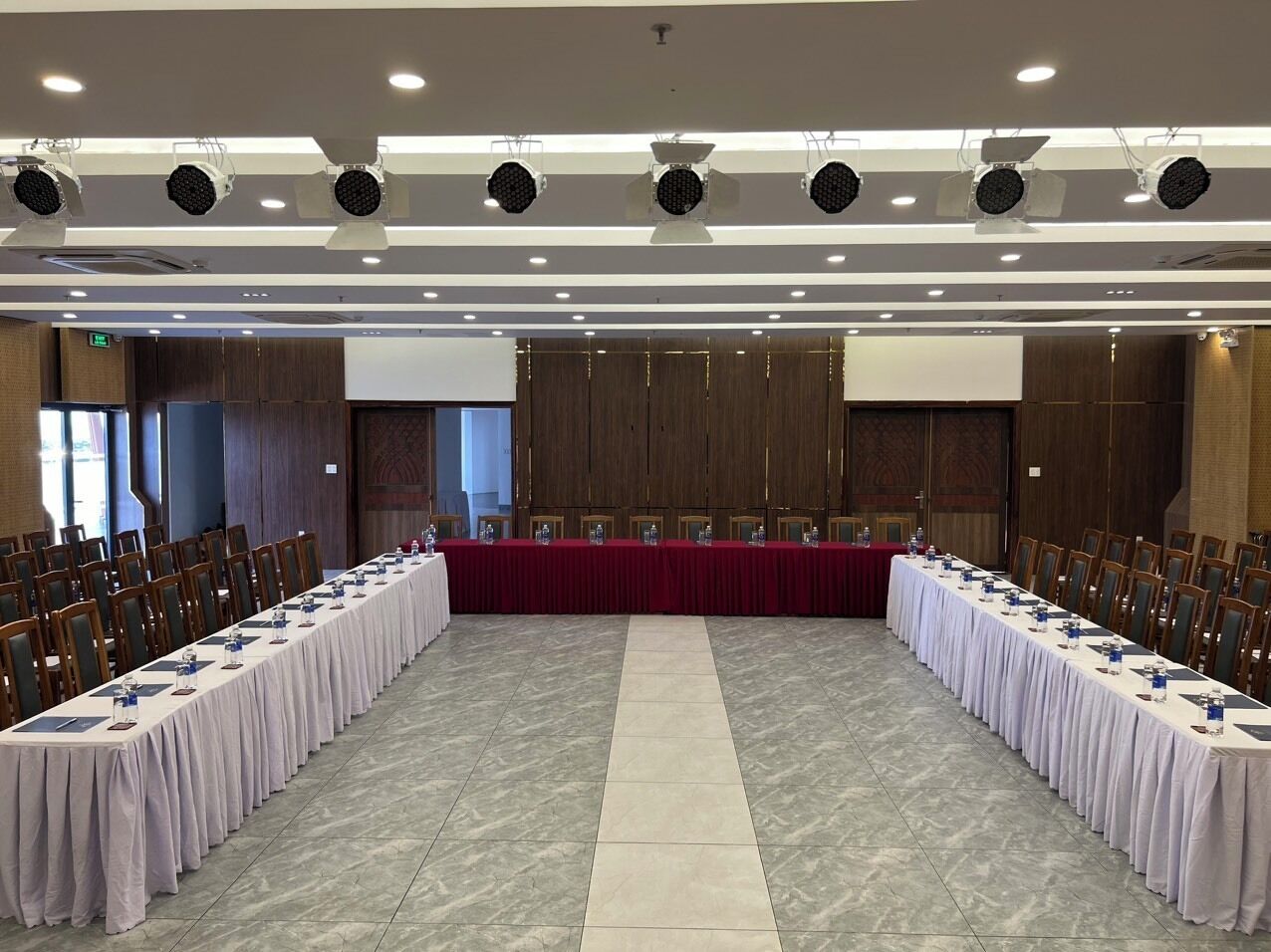 A conference room with a long table, chairs, and a projector screen.