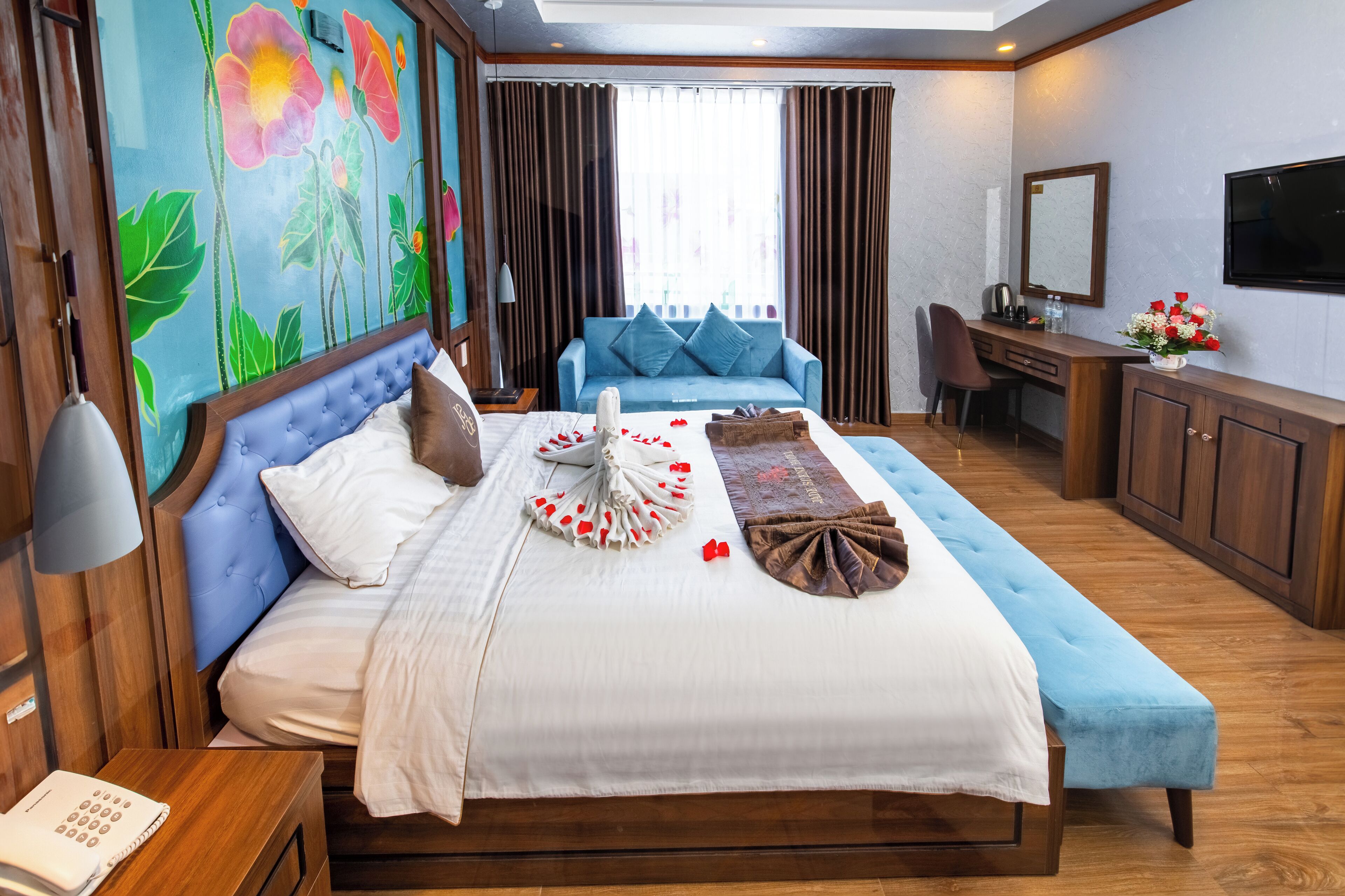Una habitación de hotel con cama, sofá, escritorio y televisor.