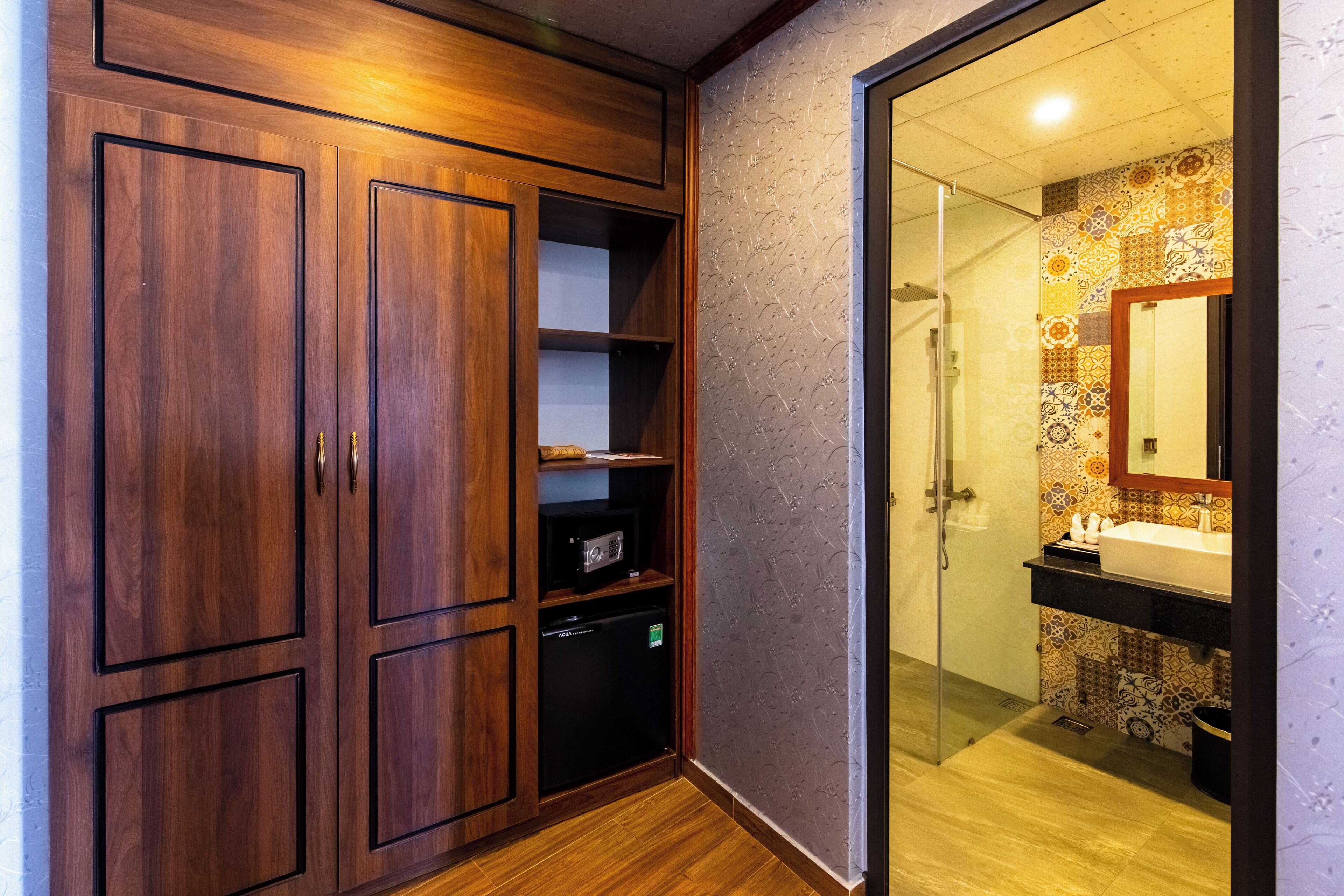 A bathroom with a wooden cabinet, a microwave, and a sink with a patterned backsplash.