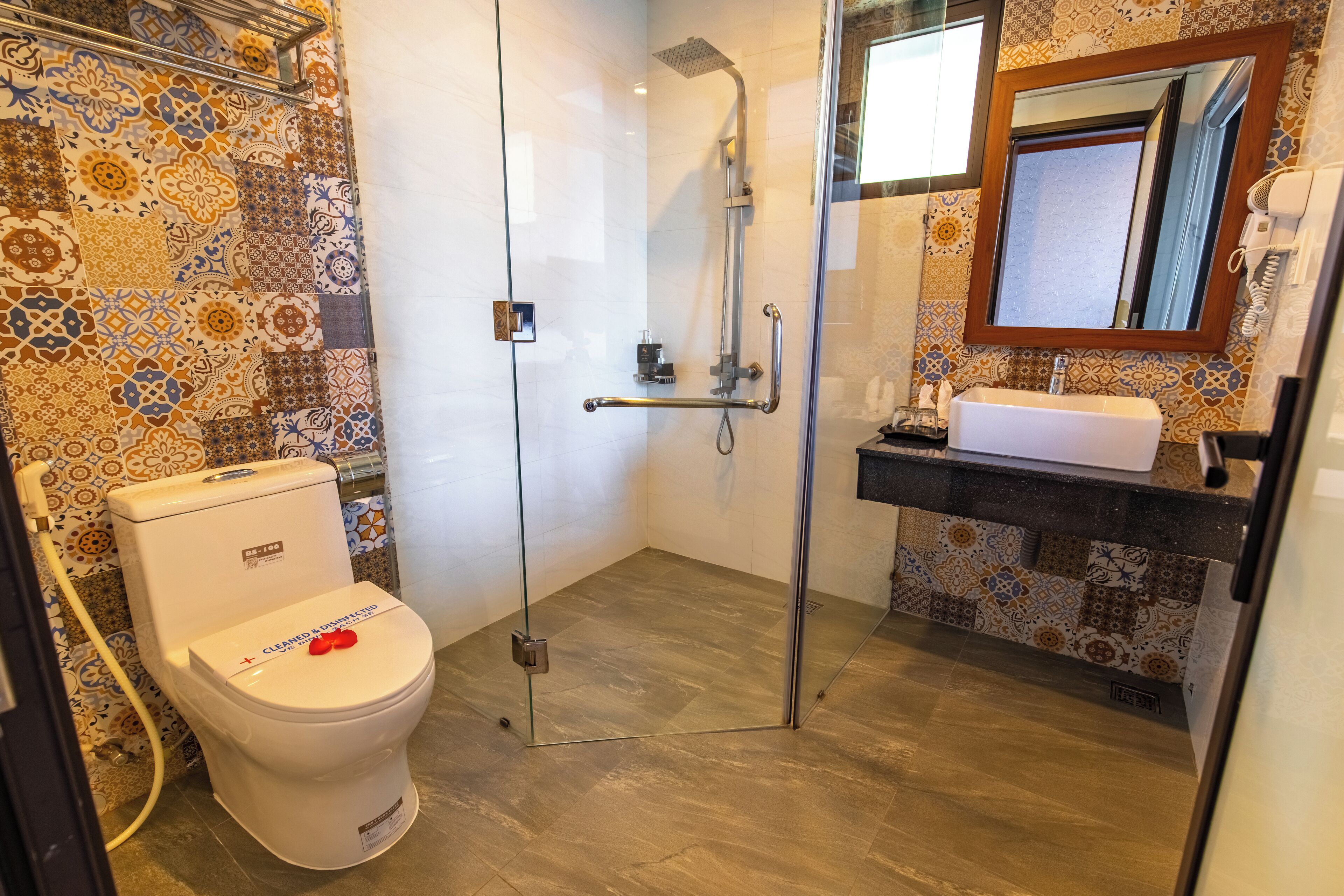 A bathroom with a toilet, shower, and sink.