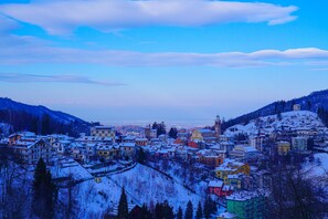 Un pueblo cubierto de nieve con edificios y una iglesia en la colina.