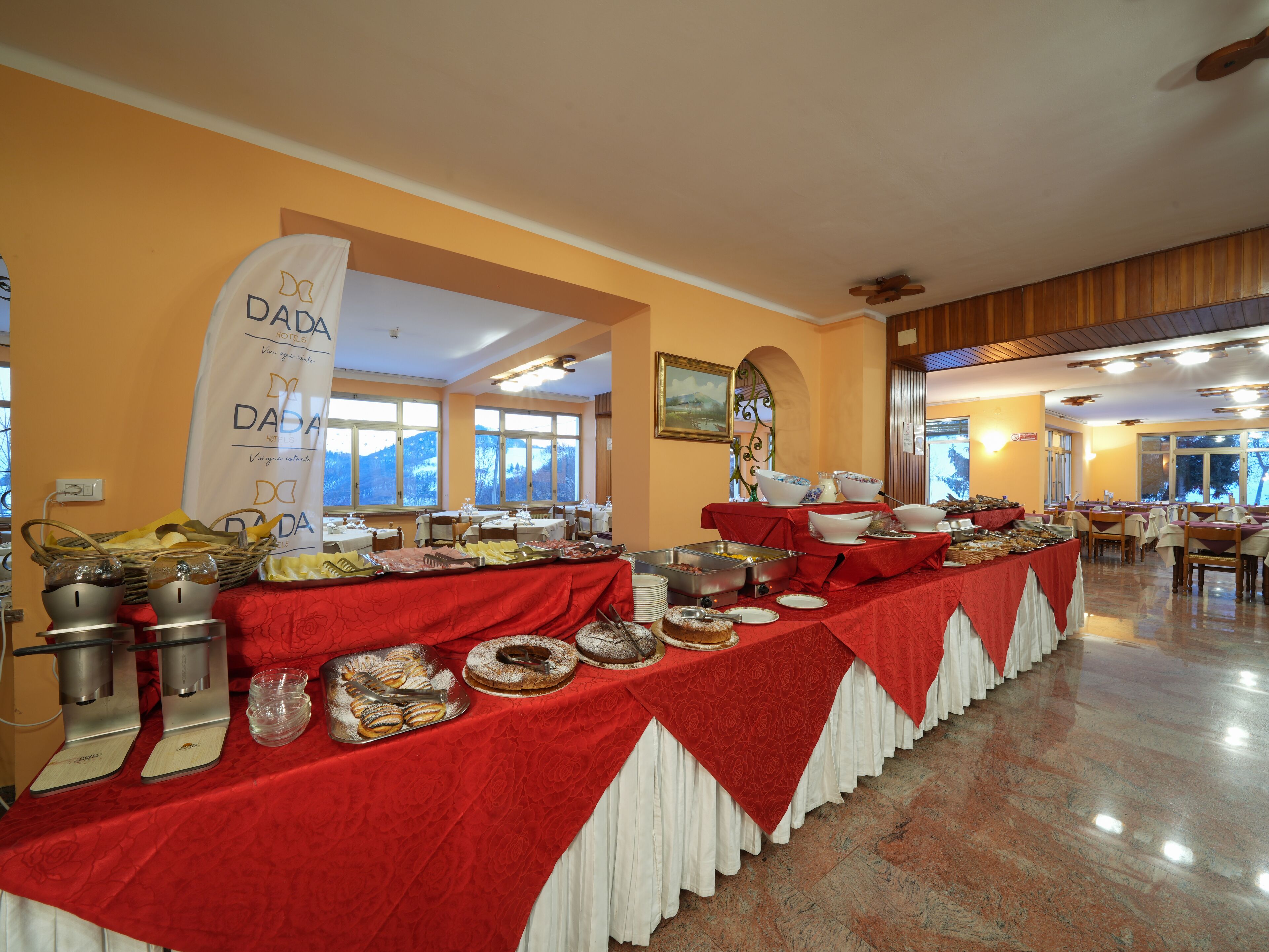 A buffet setup with various food items and a banner for DADA HOTELS.