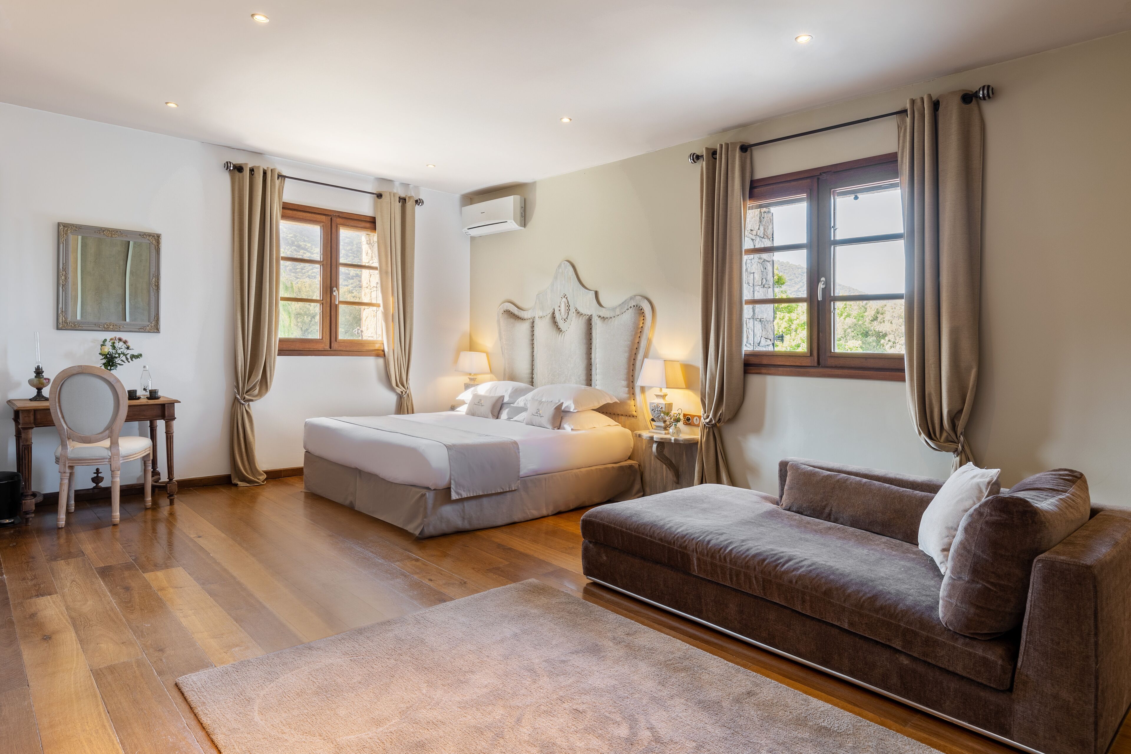 A bedroom with two beds, a sofa, a desk, and a chair.