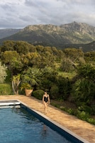 Área de piscina com vista para montanhas e vegetação.