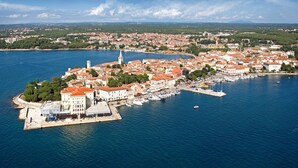 An aerial view of a coastal town with a prominent church tower, a marina with boats, and a mix of residential and commercial buildings. - Villa Diana private Pool (Varvari, Poreč)