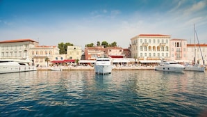 A marina with several yachts docked, surrounded by historic buildings with red-tiled roofs and white facades. - Villa Diana private Pool (Varvari, Poreč)
