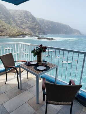 A balcony with a table set for two, overlooking a coastal area with boats and cliffs. - Willst DU Meer - Bitte Sehr ! (Tacoronte)