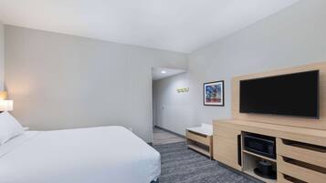 Chambre, 1 très grand lit, réfrigérateur et four à micro-ondes | Bureau, fer et planche à repasser