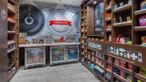 Een presentatiegedeelte voor snacks met planken vol met verschillende snacks en een koeltoog.