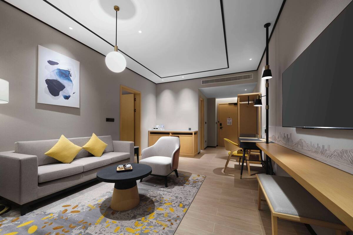 Una sala de estar moderna con un sofá, un sillón, una mesa de centro y un televisor.