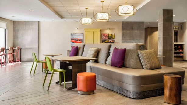 Een moderne zithoek met een bank, stoelen en een tafel.