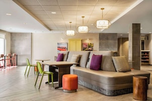 Un área de estar moderna con un sofá, sillas y una mesa.