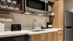 Een moderne keuken met roestvrijstalen apparatuur, een vaatwasser en houten kastjes.