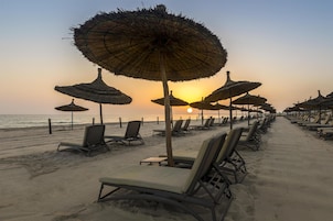 Playa privada, arena blanca, sillas reclinables de playa, sombrillas