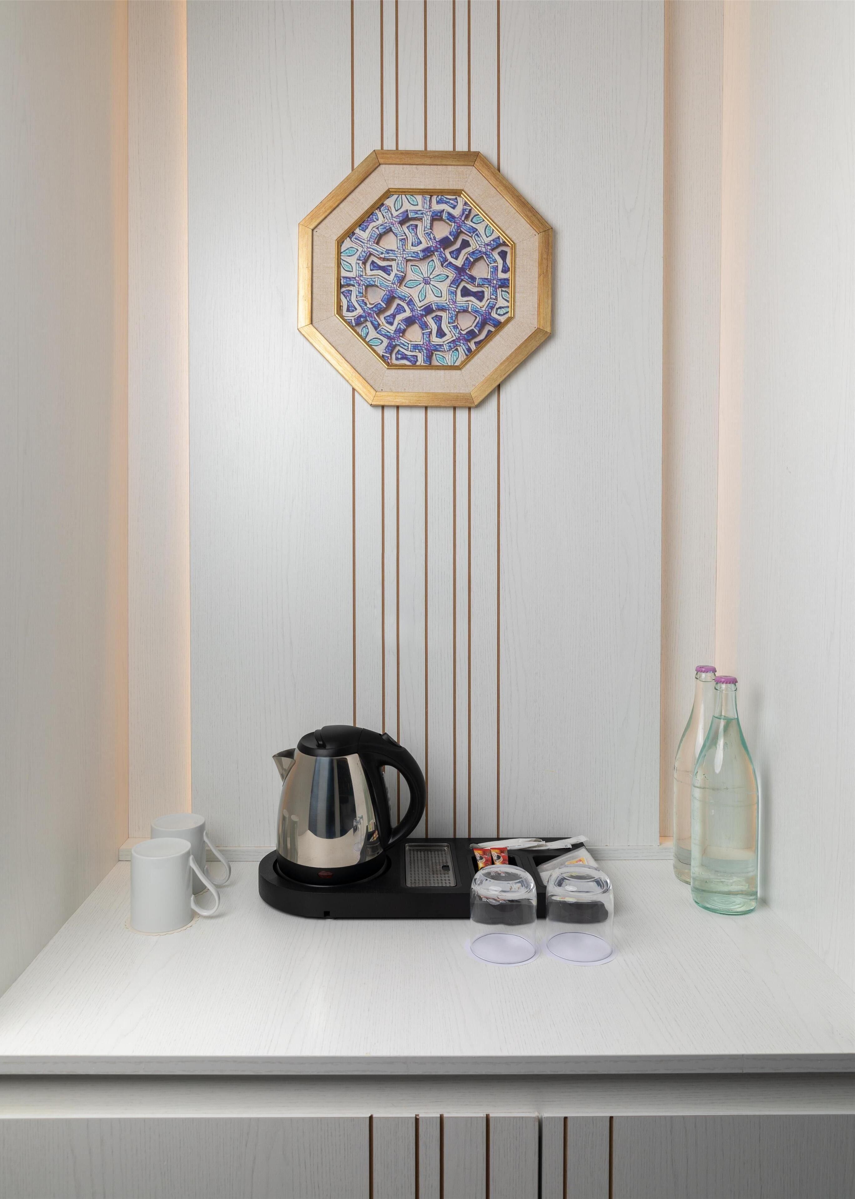 A neatly arranged breakfast bar with a coffee maker, cups, and condiments.