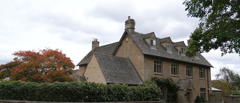 Un bâtiment en pierre avec un toit à deux versants, une cheminée et une enseigne indiquant « Wychwood Court ».