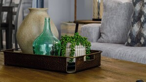 Ein Wohnzimmer mit Couch, Tisch, Lampe und Dekoration.