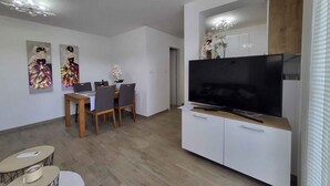 A modern living room with a dining area, a flat-screen TV, and a kitchen area. - Holiday flat just 200m from the beach (Vantačići)