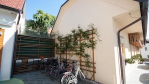 Una bicicleta estacionada frente a un edificio con techo inclinado y una valla de madera.