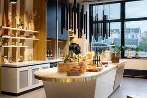 A modern kitchen with a central island, wooden shelves, and hanging pendant lights.