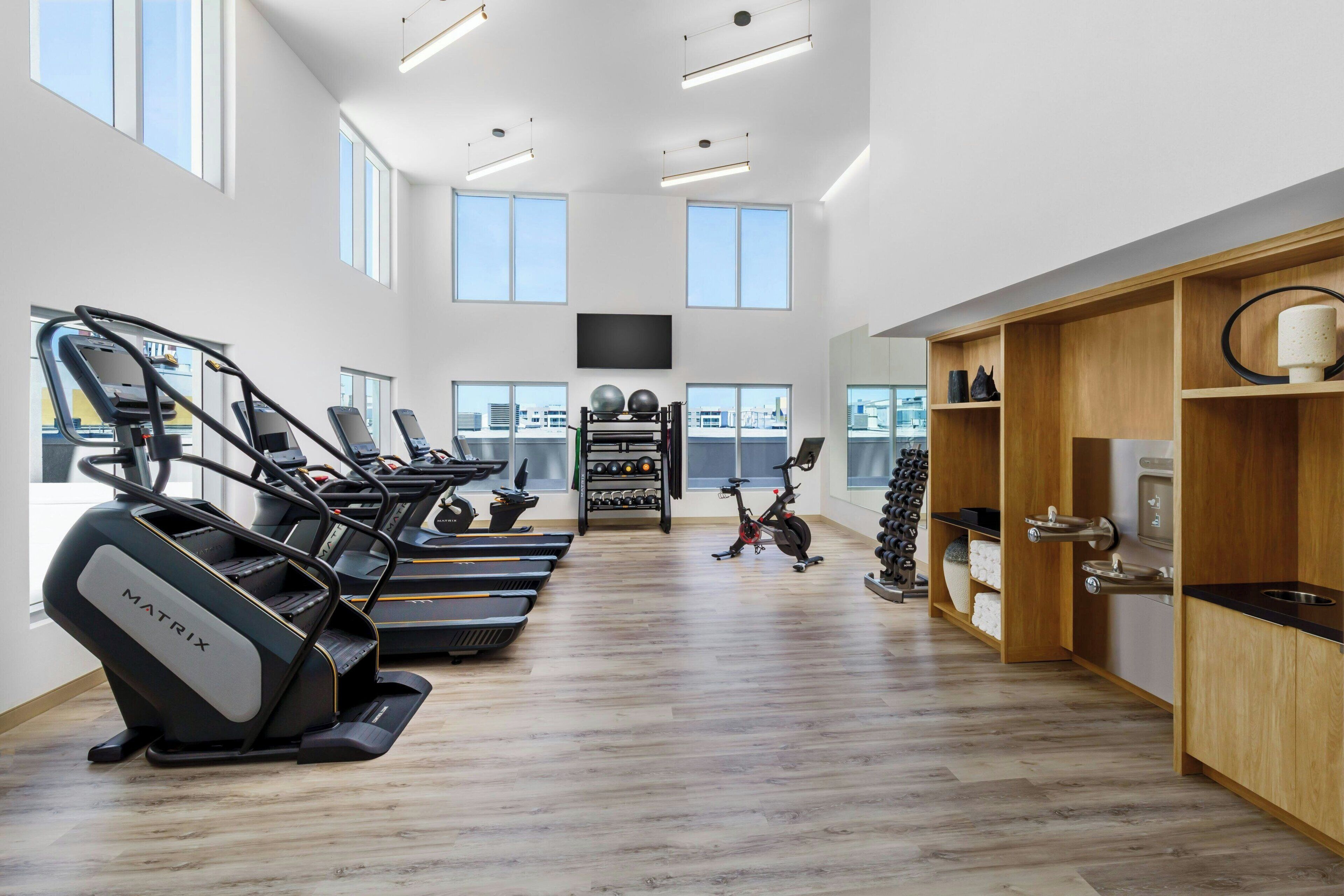 A spacious gym with treadmills, stationary bikes, and exercise balls.