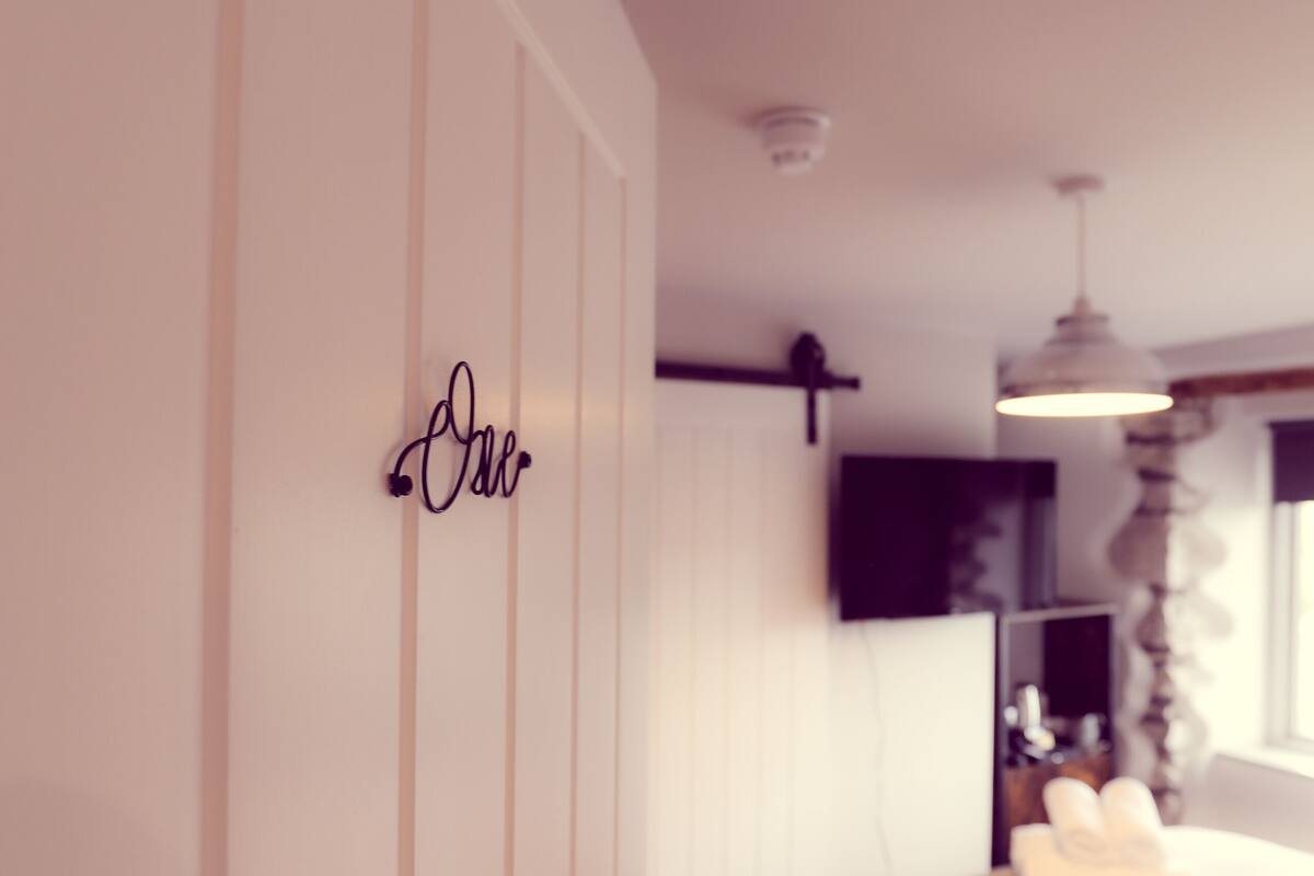 A bedroom with a bed, a bedside table, a lamp, and a wardrobe.
