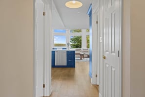 A hallway leading to a kitchen with a view of the outdoors. - Muskokan Mirage Located on Mirage Lake (Novar)