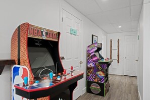 A hallway with two arcade machines, one labeled 'NBA JAM' and the other 'Turtles.'