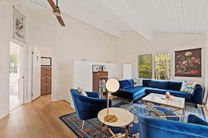 A modern living room with a blue sectional sofa, a round coffee table, and a patterned rug. - Muskokan Mirage  Located on Mirage Lake (Novar)