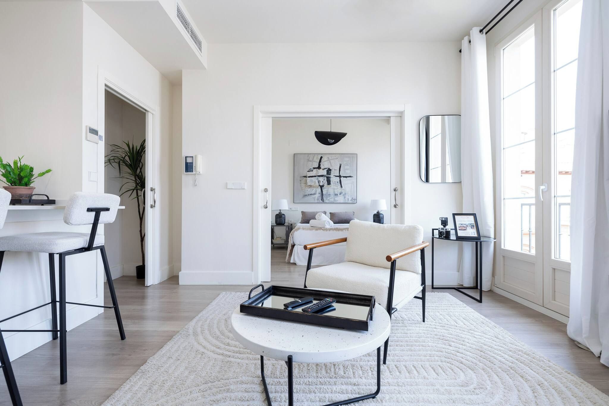 Una sala moderna con sofá, mesa de centro y comedor con sillas.