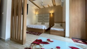 A bedroom with two beds, a wooden partition, a ceiling fan, and an air conditioning unit.
