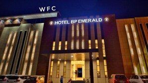 A hotel entrance with a modern design, featuring vertical light strips and a prominent sign.