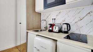 Eine kompakte Küche mit Mikrowelle, Toaster und Kaffeemaschine auf der Arbeitsfläche.