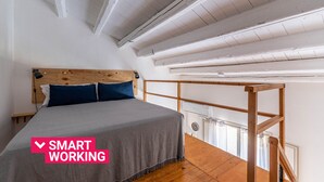 A bedroom with a bed, wooden headboard, and a balcony with a wooden railing. - Sant'Onofrio Mini Loft by Wonderful Italy (Palermo)