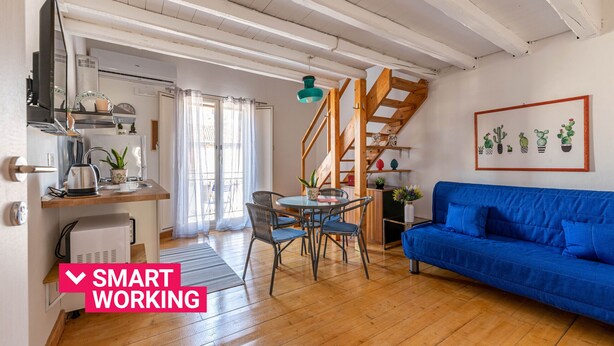 A modern living space with a kitchen, dining area, and a blue sofa. - Sant'Onofrio Mini Loft by Wonderful Italy (Palermo)