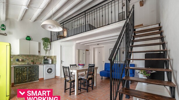 Ein modernes Apartment mit Küche, Essbereich und einer Treppe.