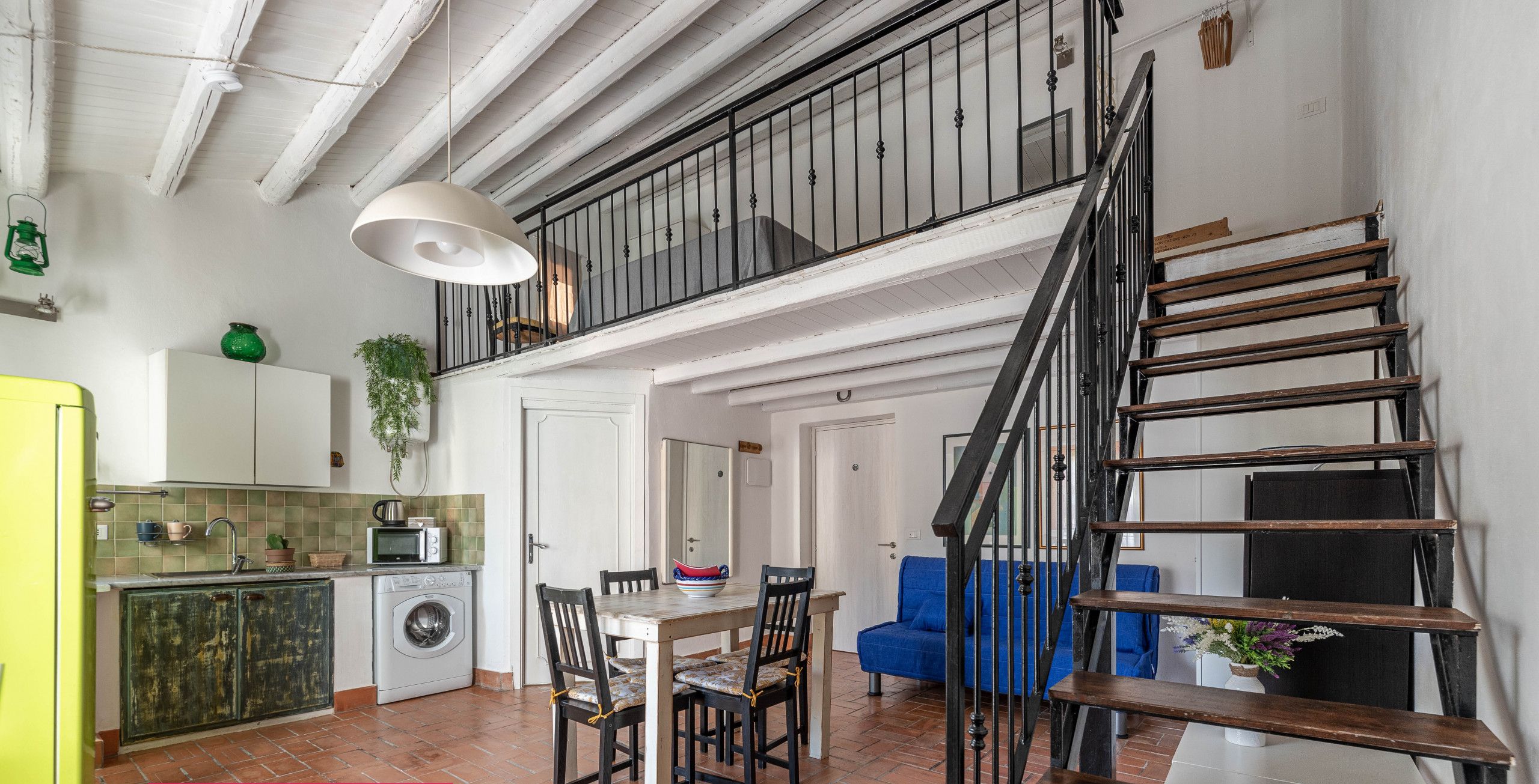 Un appartement moderne doté d’une cuisine, d’un coin repas et d’un escalier.