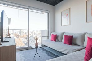Una sala de estar moderna con un sofá, una mesita y un jarrón decorativo.