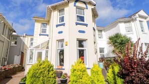 A multi-story residential building with a central entrance, large windows, and a balcony. - English Riviera Coastal Holiday Home in Devon Uk (Paignton)