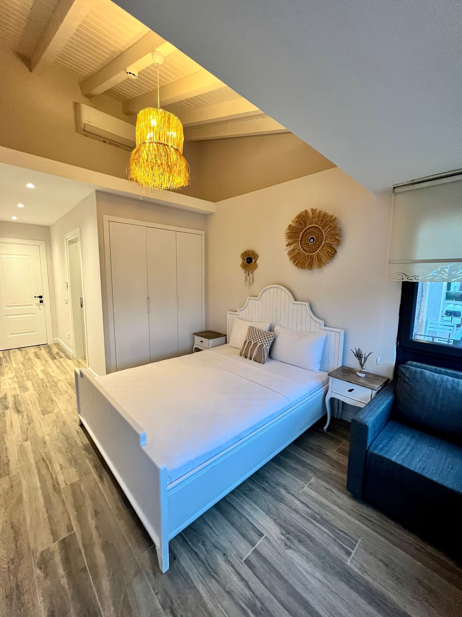 A bedroom with a large bed, a nightstand, a dresser, and a ceiling fan.