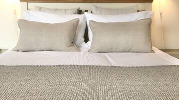 A neatly made bed with a patterned bedspread, two pillows, and a framed picture above it.