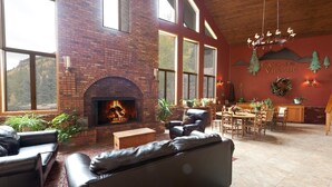 A cozy lounge area with a fireplace, leather sofas, and a dining area with a wooden table and chairs. - Silver Vista End Unit | Pool & Ski Shuttle, Hot Tub, Fireplace, Balcony (Durango)