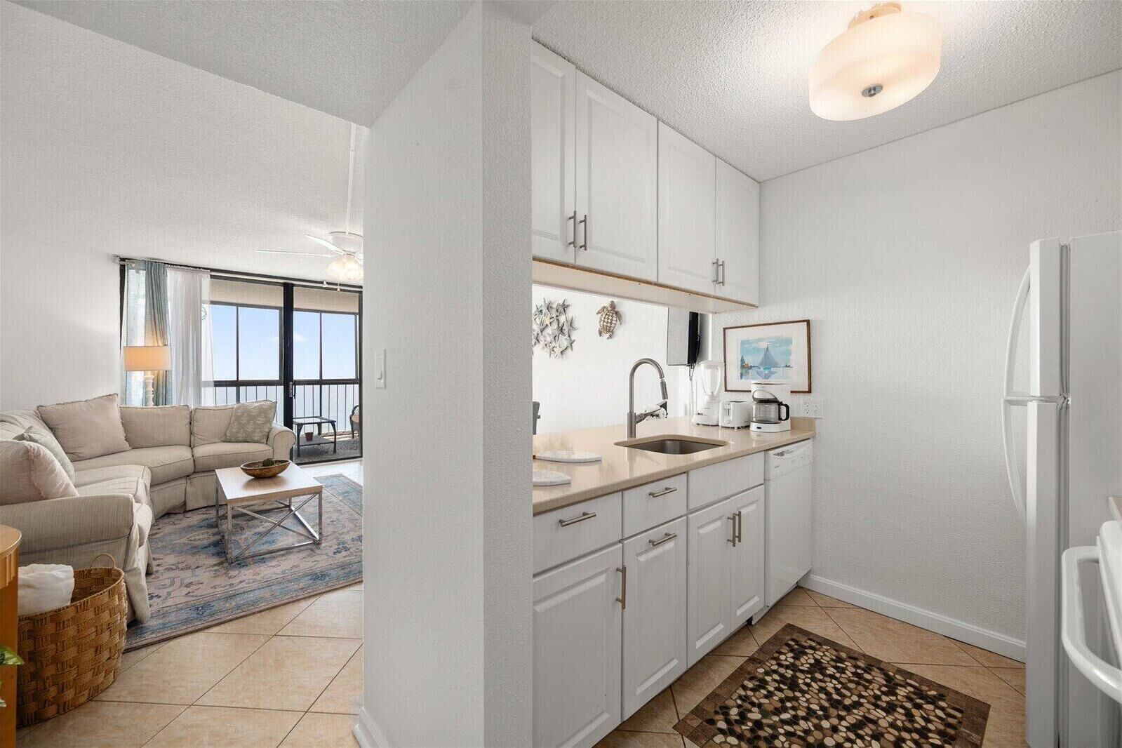 A modern apartment with a living room, kitchen, and balcony.