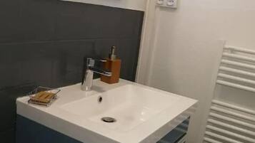 Een koelkast, een kookplaat, een waterkoker, kookgerei, borden en bestek