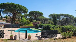 A private pool area with a stone deck, surrounded by a black fence, and a covered seating area with a pergola. - le Mas du Rouquan (Vidauban)