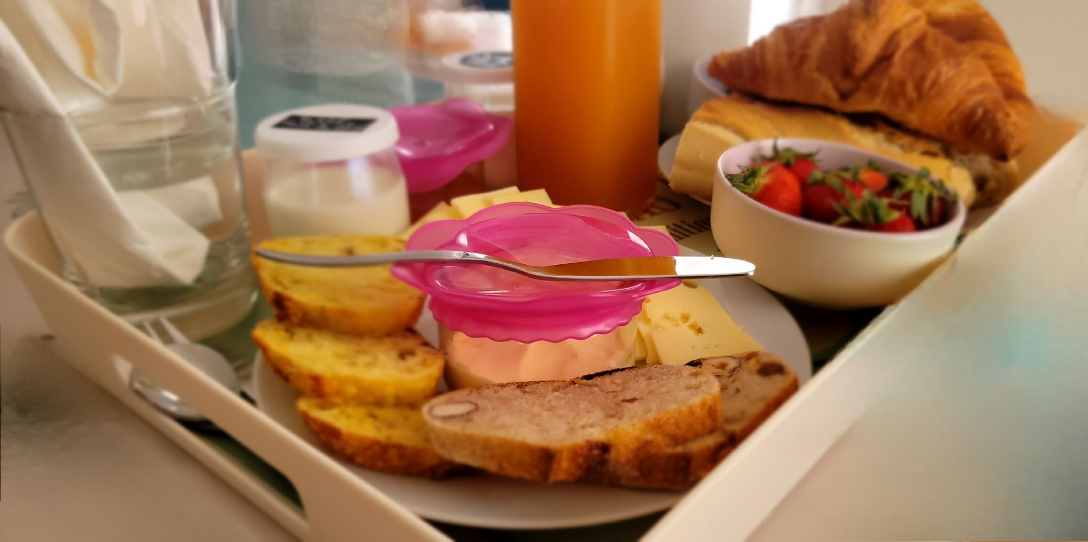 Ein Frühstückswagen mit Brot, Butter, einem Croissant und einer Obstschale.